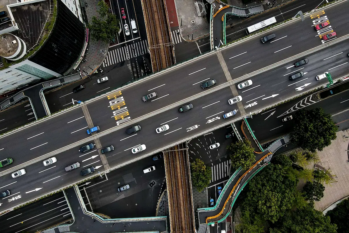 Overhead view of a multilane highway crossing over a rail line.