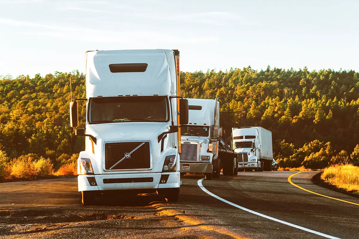 Semi-trucks rounding a curve on a highway in Arizona.